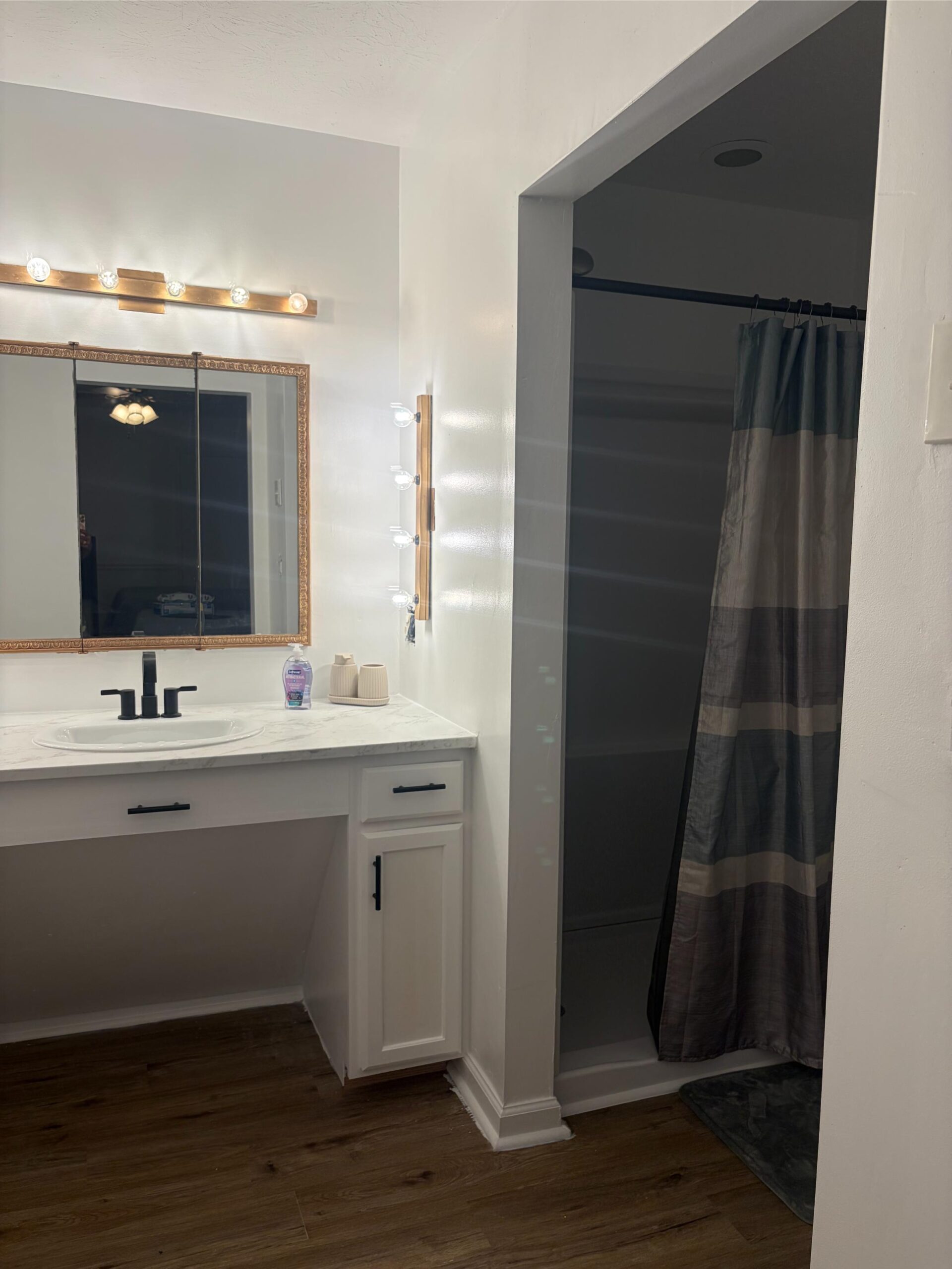 Bathroom with vanity, mirror, and shower
